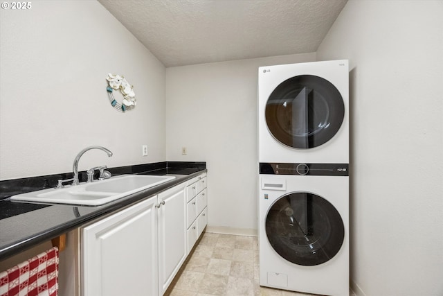 19580 SW 56th Ct, Tualatin, OR 97062 - washroom featuring stacked washer / dryer, cabinet space, and a textured ceiling