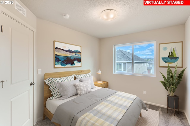 carpeted bedroom featuring visible vents, a textured ceiling, and baseboards