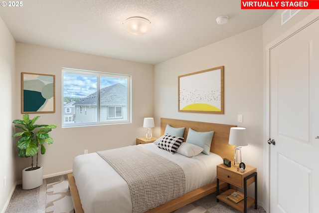 carpeted bedroom featuring visible vents, baseboards, and a textured ceiling