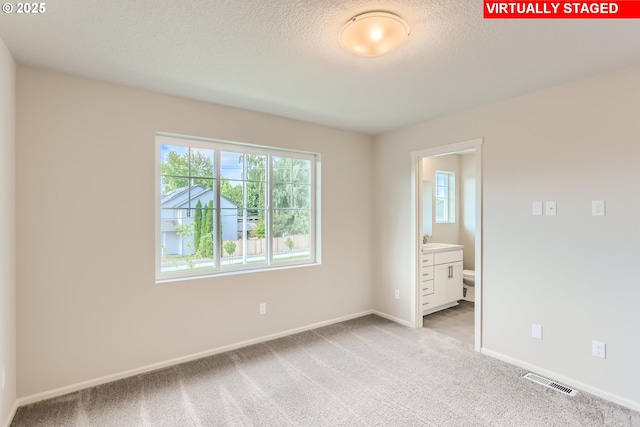 unfurnished bedroom with visible vents, light colored carpet, baseboards, and multiple windows