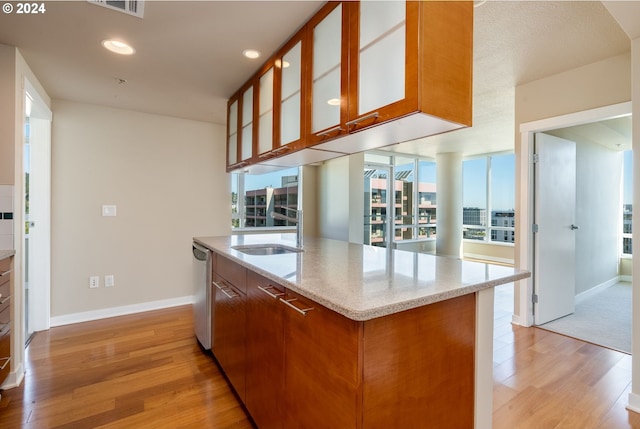 1500 SW 11th Ave Unit 1703, Portland, OR 97201 - kitchen featuring glass insert cabinets, light stone countertops, light wood-type flooring, and baseboards