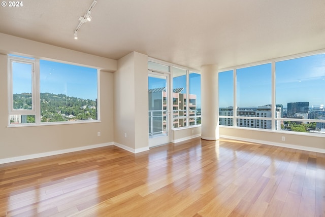 1500 SW 11th Ave Unit 1703, Portland, OR 97201 - unfurnished room featuring a city view, baseboards, track lighting, and light wood-style floors