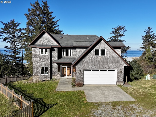 view of front of property featuring a garage, a front yard, driveway, and fence