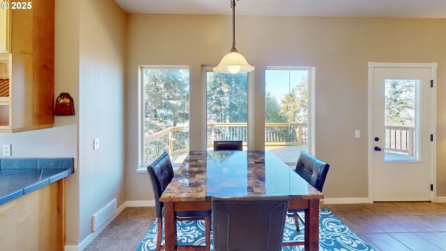 dining space with tile patterned flooring, baseboards, and visible vents