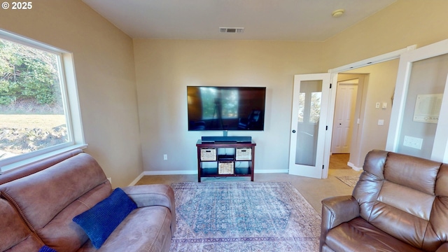 living room featuring carpet, french doors, visible vents, and baseboards