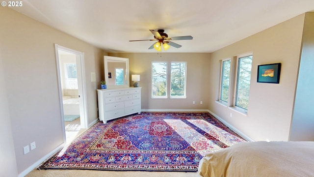 bedroom with connected bathroom, a ceiling fan, and baseboards