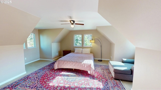 carpeted bedroom featuring multiple windows, ceiling fan, baseboards, and vaulted ceiling