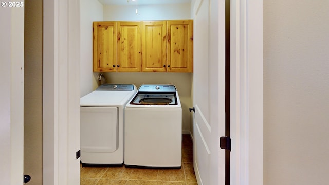 washroom with washer and dryer, light tile patterned floors, and cabinet space