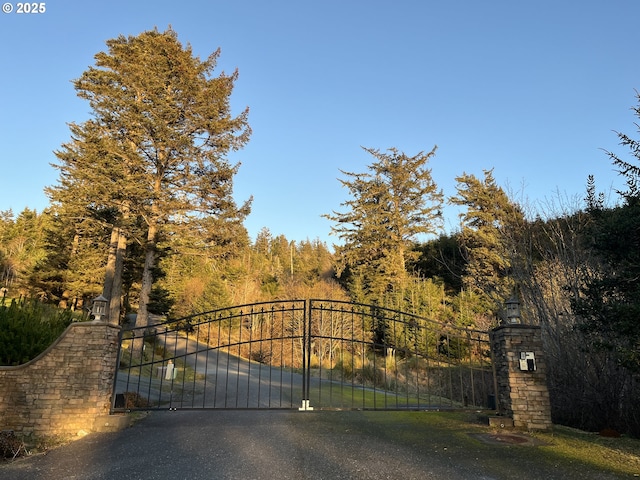 view of gate with a view of trees