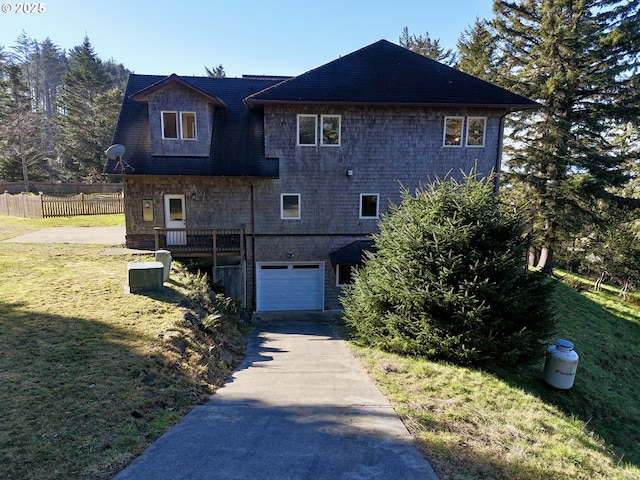 view of front facade featuring concrete driveway, an attached garage, fence, and a front yard