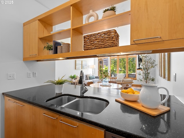 kitchen with a sink, dark stone counters, open shelves, and open floor plan
