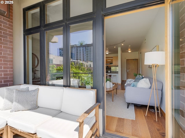 exterior space featuring brick wall and wood finished floors