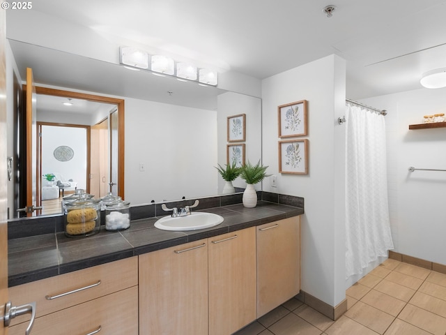 full bath featuring baseboards, a shower with shower curtain, tile patterned flooring, and vanity