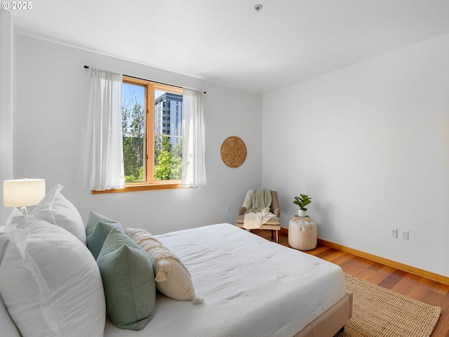 bedroom featuring baseboards and wood finished floors