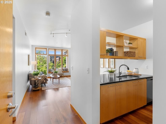 1030 NW Johnson St Unit 520, Portland, OR 97209 - bar with dark wood-style flooring, track lighting, a sink, and dishwasher
