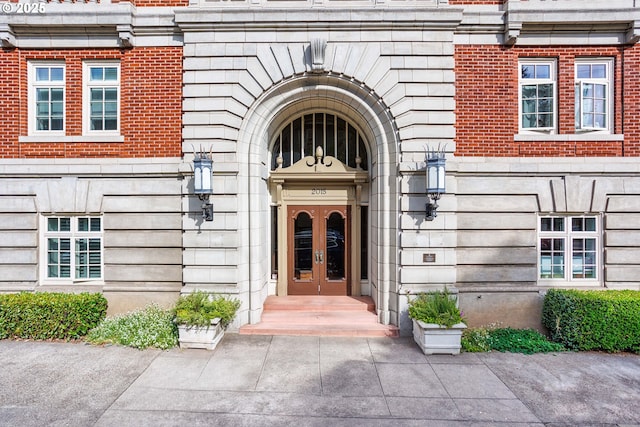 view of exterior entry with brick siding and french doors