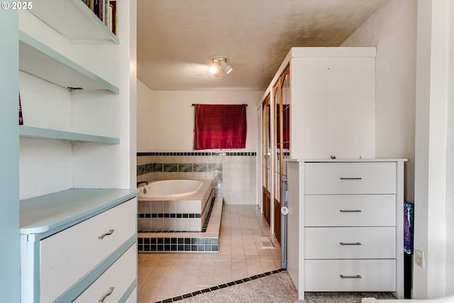 bathroom with tiled bath and tile patterned floors