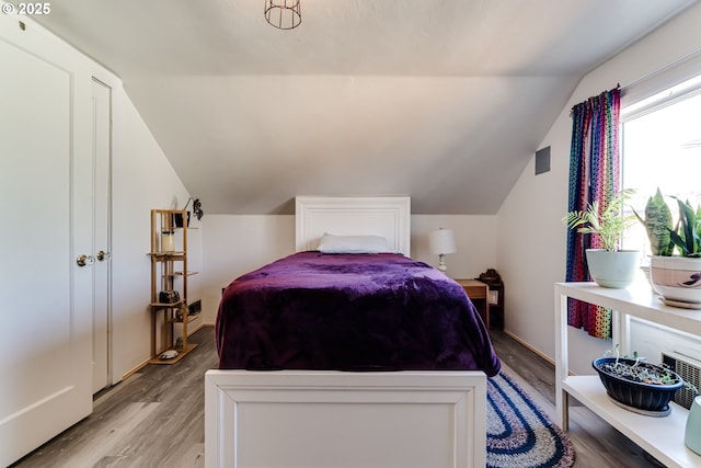 bedroom featuring light hardwood / wood-style flooring and vaulted ceiling