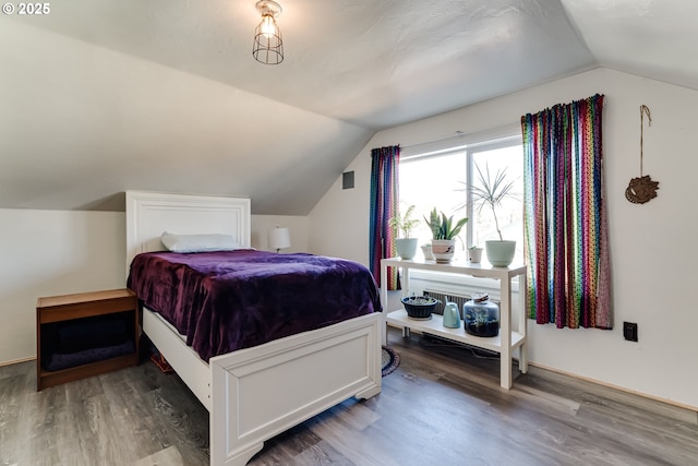 bedroom with dark hardwood / wood-style flooring and vaulted ceiling