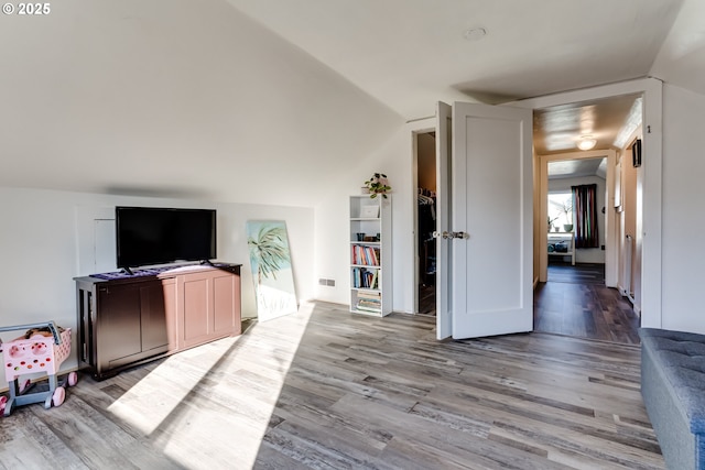 living room with vaulted ceiling and light wood-type flooring