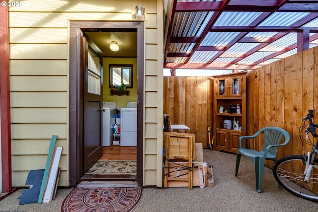 exterior space featuring wooden walls, washing machine and clothes dryer, and carpet