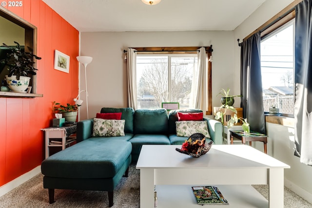 carpeted living room with plenty of natural light and wooden walls