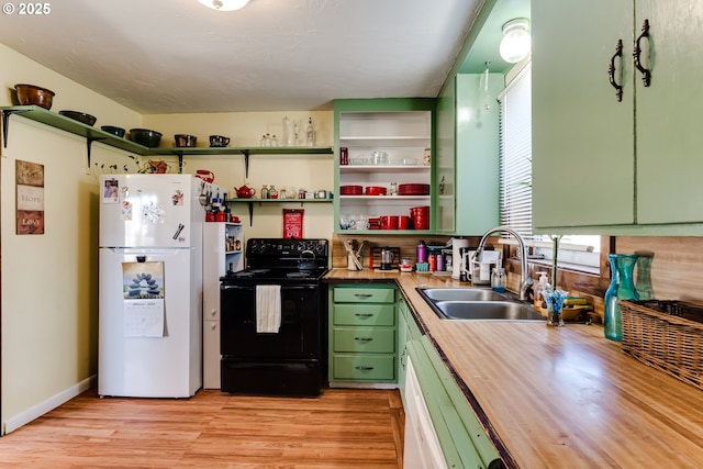 kitchen featuring sink, butcher block countertops, green cabinetry, black electric range, and white refrigerator