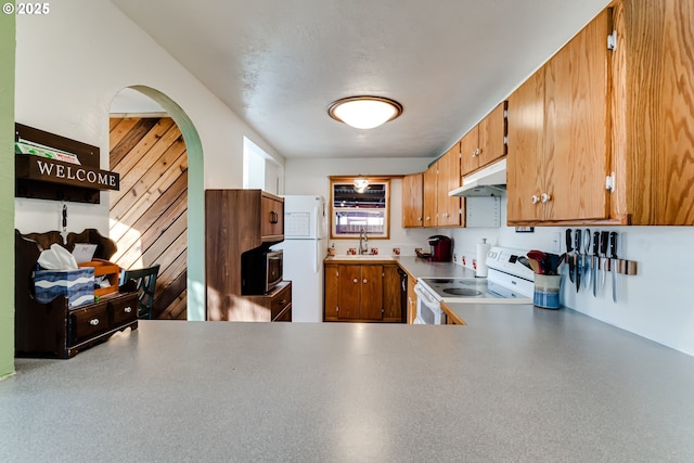 kitchen featuring sink, white appliances, and kitchen peninsula