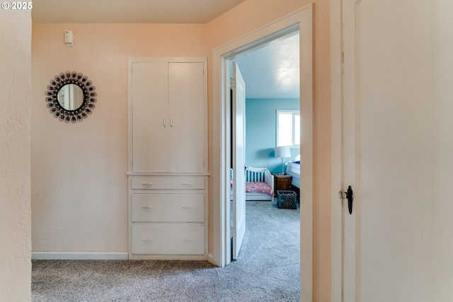 corridor featuring light colored carpet