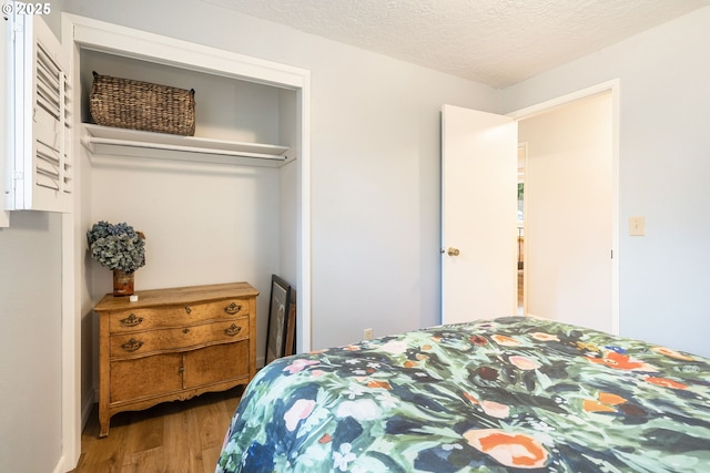 bedroom featuring a textured ceiling and wood finished floors