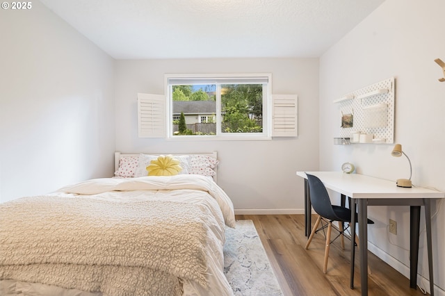 bedroom with baseboards and wood finished floors