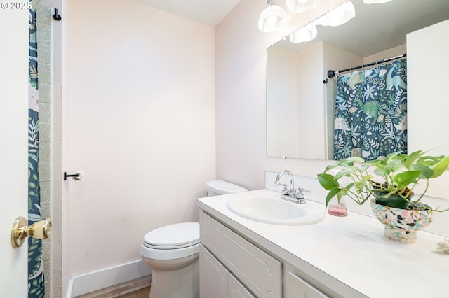 bathroom with vanity, baseboards, toilet, and wood finished floors
