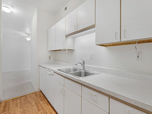 4320 S Corbett Ave Unit 206, Portland, OR 97239 - kitchen with a sink, light wood finished floors, light countertops, white cabinets, and baseboards