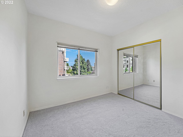 4320 S Corbett Ave Unit 206, Portland, OR 97239 - unfurnished bedroom with carpet flooring, a closet, and baseboards