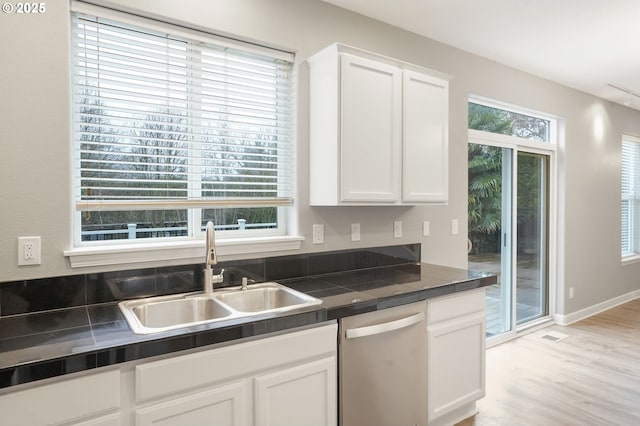 kitchen featuring light wood-type flooring, dishwasher, sink, and white cabinets