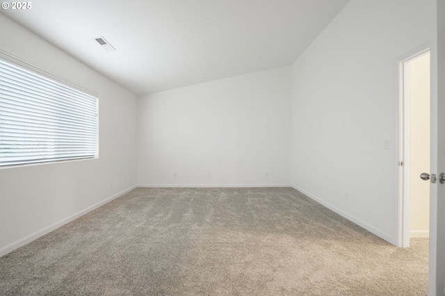 empty room with light carpet and vaulted ceiling