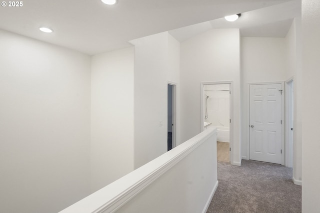 corridor featuring a towering ceiling and carpet flooring