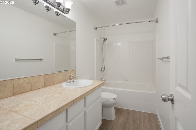 full bathroom with shower / washtub combination, toilet, hardwood / wood-style floors, and vanity