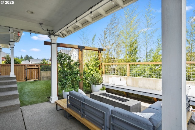 view of patio / terrace featuring an outdoor living space with a fire pit and fence
