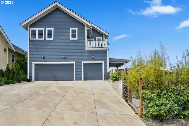 view of home's exterior with a garage, driveway, and a balcony