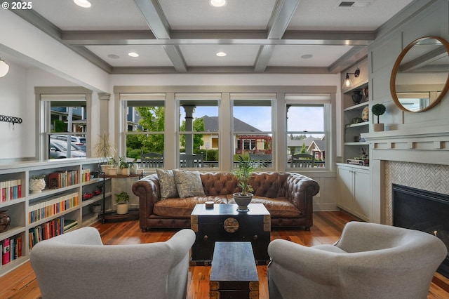 living room with healthy amount of natural light, wood finished floors, coffered ceiling, recessed lighting, and a tile fireplace