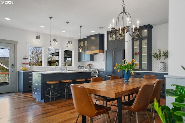 dining area with healthy amount of natural light, a chandelier, recessed lighting, and dark wood-type flooring