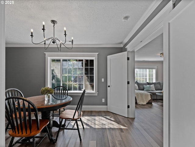 dining area featuring an inviting chandelier, crown molding, a textured ceiling, and hardwood / wood-style flooring