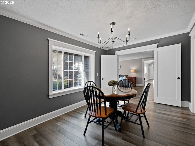 dining space featuring a textured ceiling, dark hardwood / wood-style floors, crown molding, and a notable chandelier