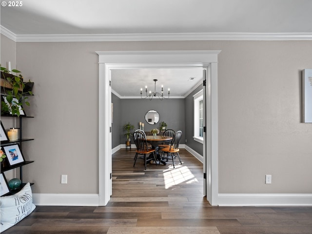 dining area with dark wood-type flooring, a notable chandelier, and crown molding