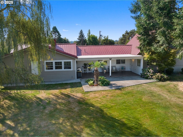 rear view of house featuring a lawn and a patio area