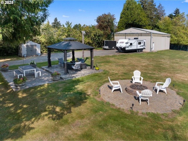 view of yard with a gazebo, a storage unit, a patio area, and a fire pit