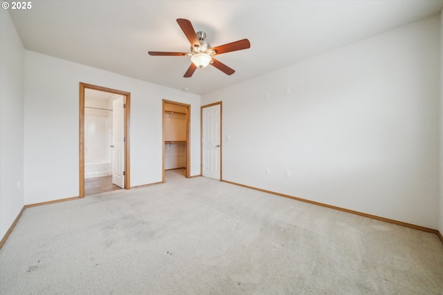 unfurnished bedroom with a closet, baseboards, ensuite bathroom, ceiling fan, and light colored carpet