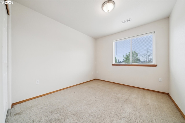 unfurnished room featuring carpet flooring, visible vents, and baseboards