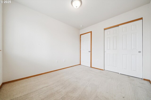 unfurnished bedroom with a closet, carpet, and baseboards